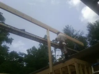 Carpenter setting a ridge beam over a new addition frame — Ice Dam Removal by Roofing Brothers in King William