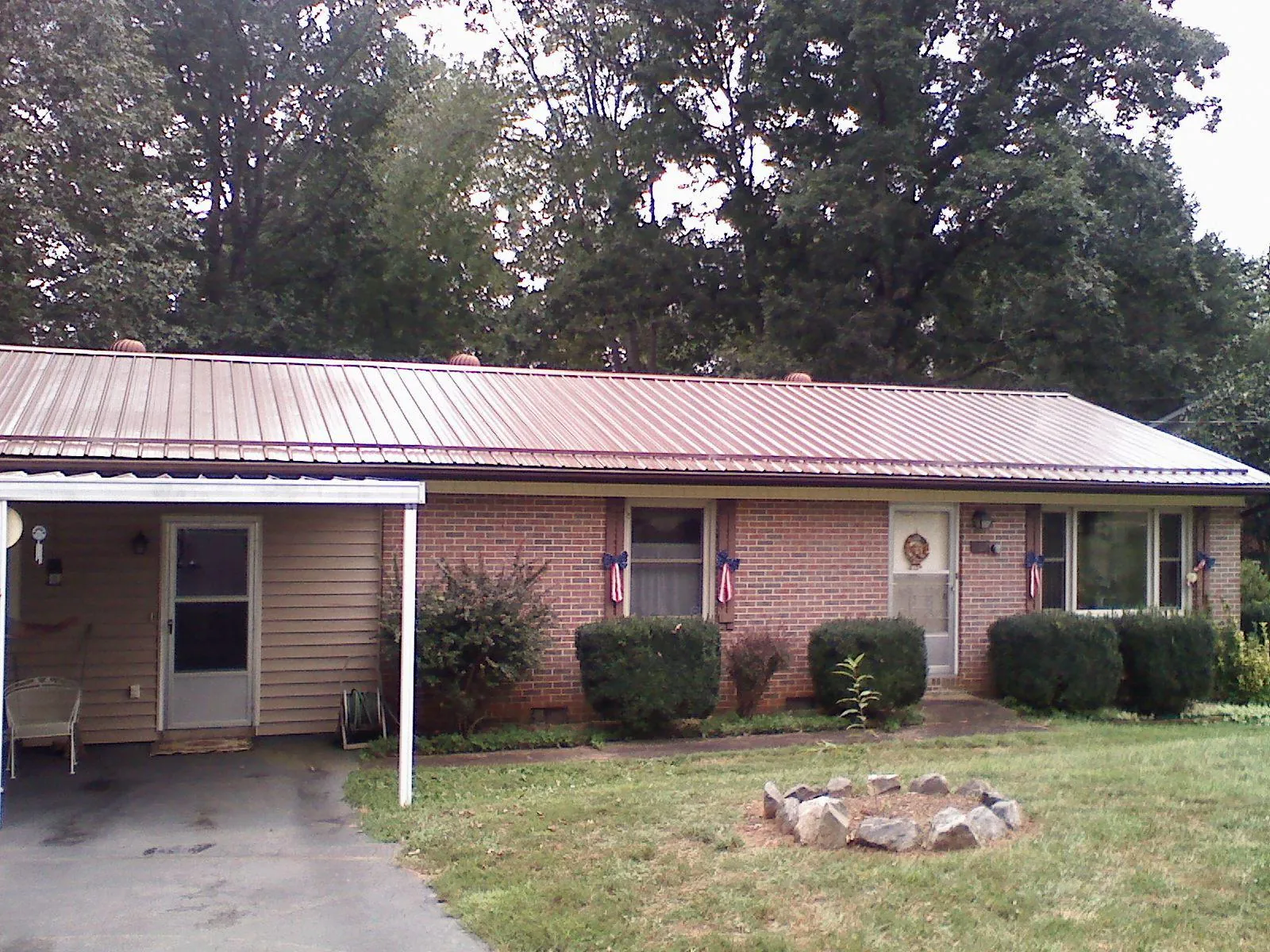 Bronze metal roof and carport on a brick ranch home — Roof Repair work by our crew in King William
